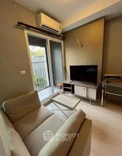 Cozy living room with modern decor and balcony access in urban apartment.