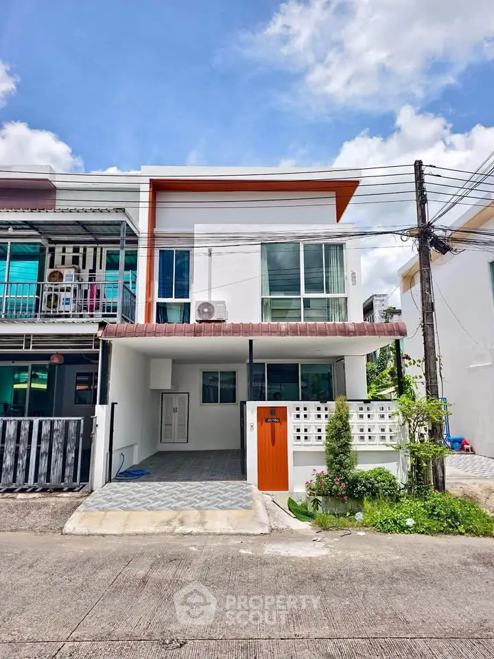 Modern two-story townhouse with sleek design and spacious driveway in a suburban neighborhood.