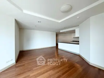 Spacious open-plan living room with hardwood floors and modern kitchen