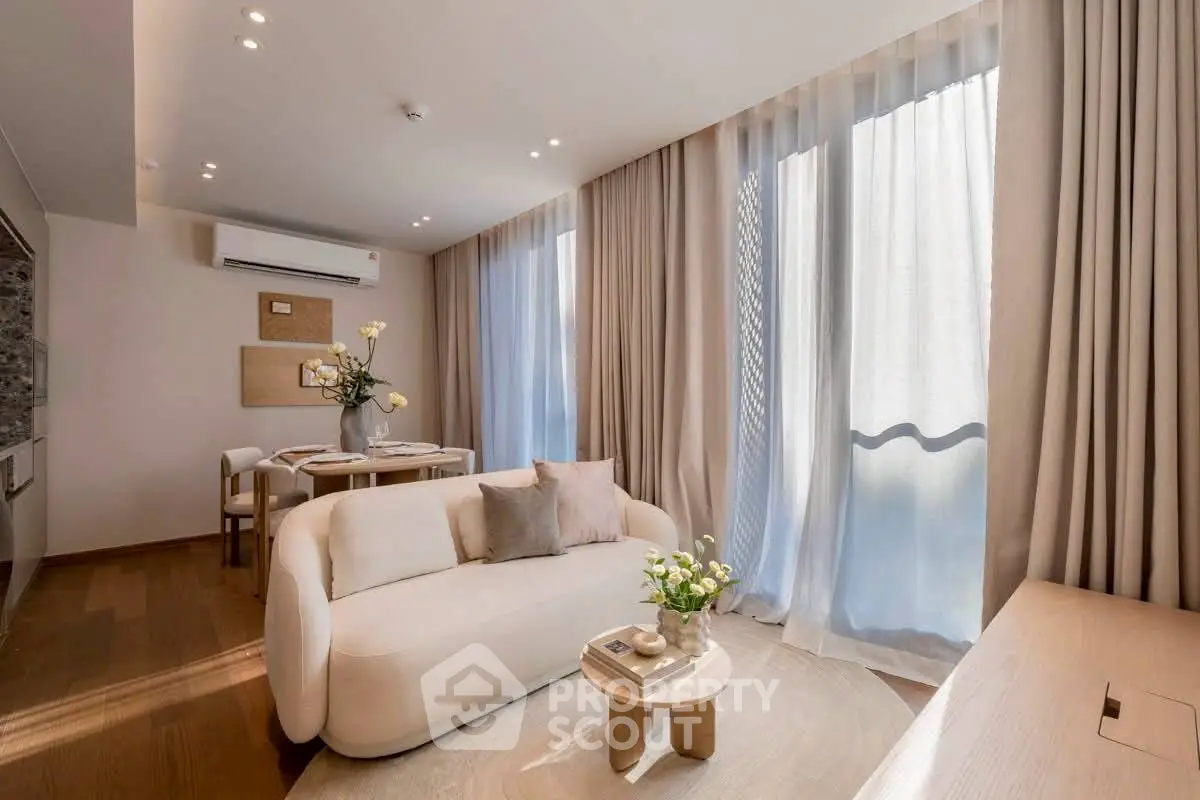 Elegant living room with modern furniture and large windows in a stylish apartment.