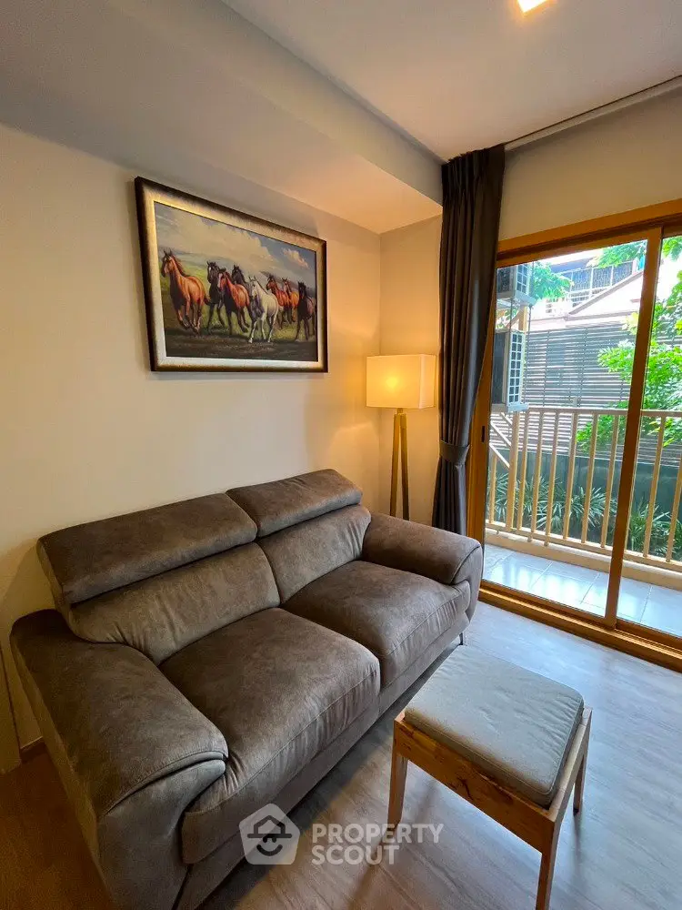Cozy living room with plush sofa, stylish decor, and balcony view in modern apartment.