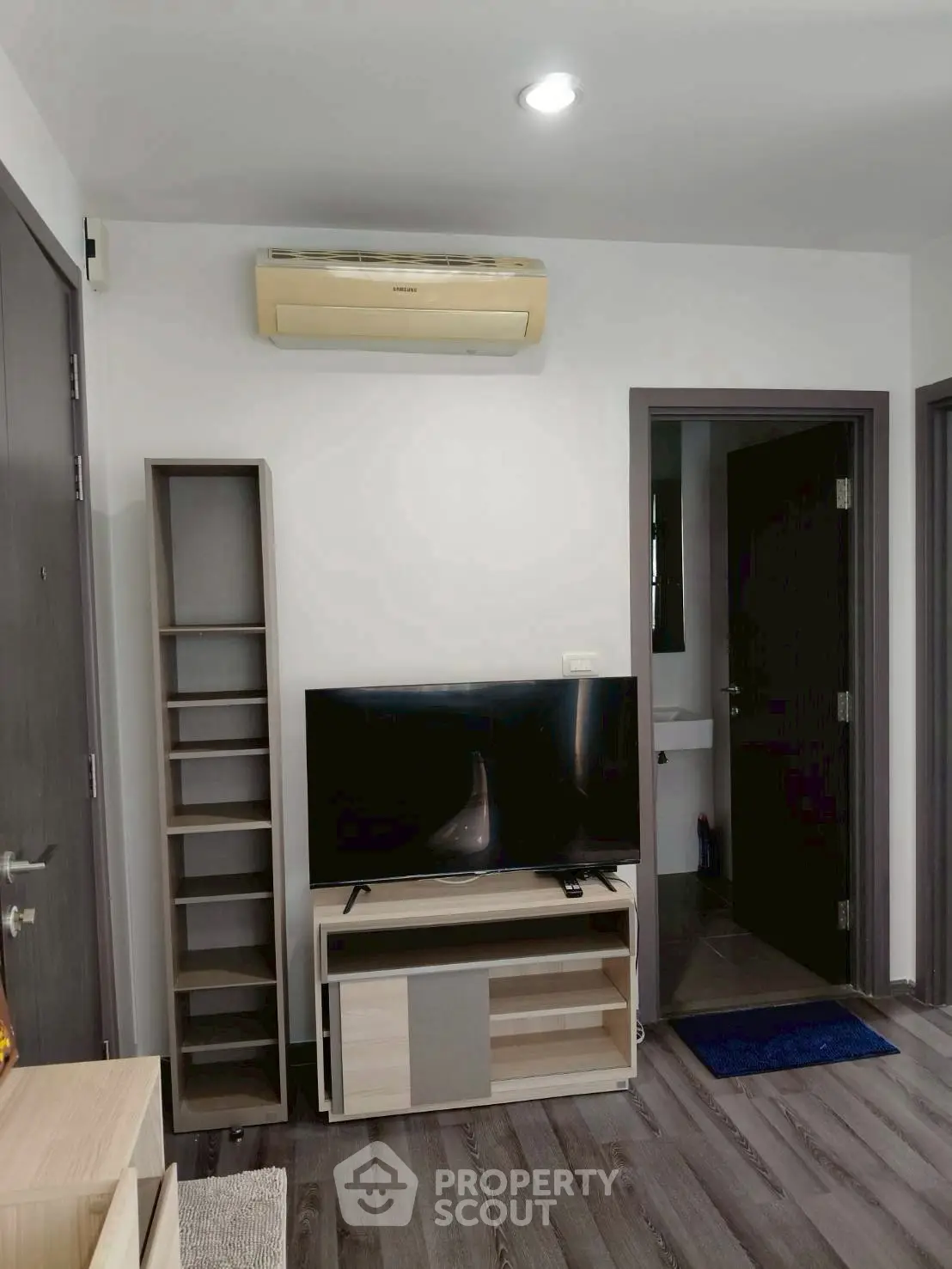 Modern living room with sleek TV unit and air conditioning, perfect for cozy entertainment.