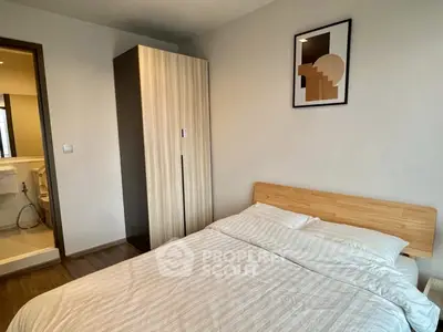 Cozy bedroom with modern decor and ensuite bathroom in stylish apartment.