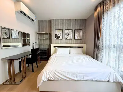 Modern bedroom with stylish decor, large window, and elegant furnishings in a contemporary apartment.