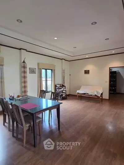 Spacious living room with wooden flooring and elegant dining area