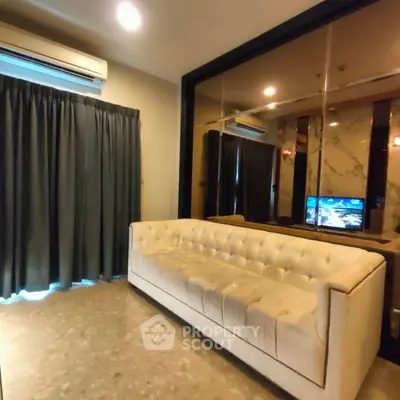 Luxurious living room with elegant sofa and mirrored wall, perfect for modern living.