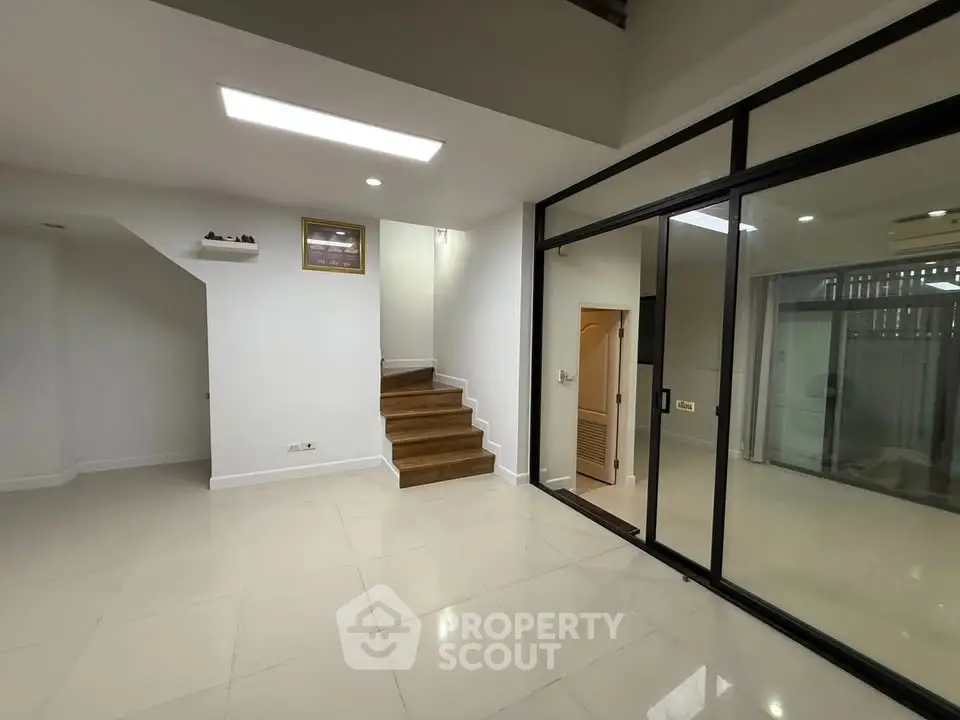 Modern interior with sleek staircase and glass doors, perfect for contemporary living.