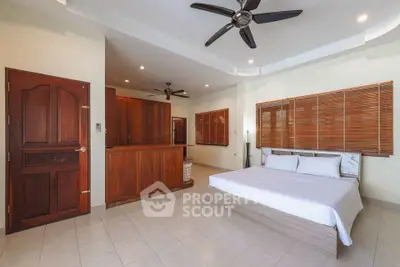 Spacious bedroom with wooden accents and ceiling fan in modern home