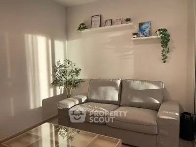 Cozy living room with modern gray sofa and decorative plants, perfect for relaxation.
