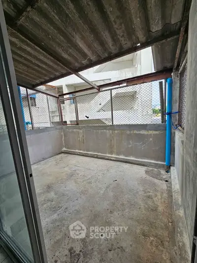 Spacious concrete balcony with industrial design and metal fencing, ideal for urban living.