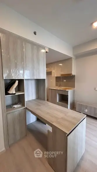 Modern kitchen with sleek cabinetry and integrated desk in a compact open layout.