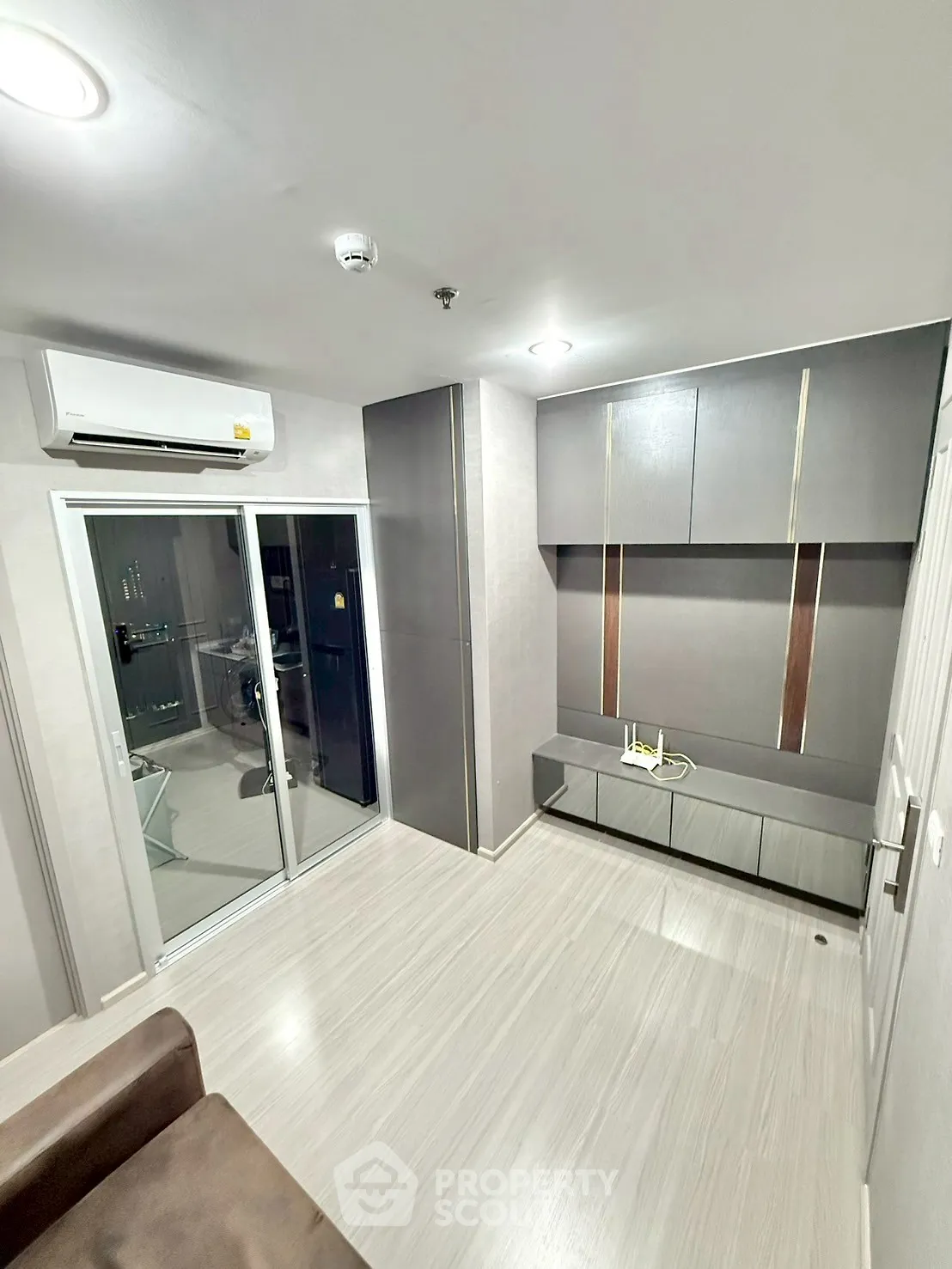 Modern living room with sleek cabinetry and air conditioning