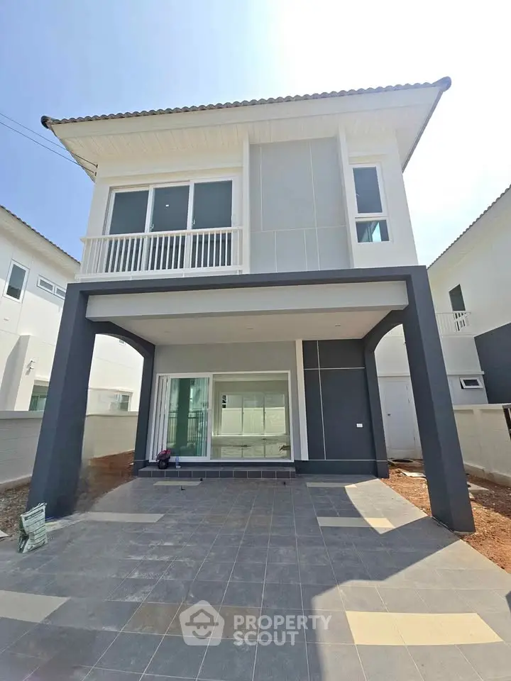 Modern two-story house with spacious driveway and elegant facade in a sunny neighborhood.