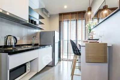 Modern kitchen with sleek design, featuring open layout, stylish lighting, and large windows for natural light.