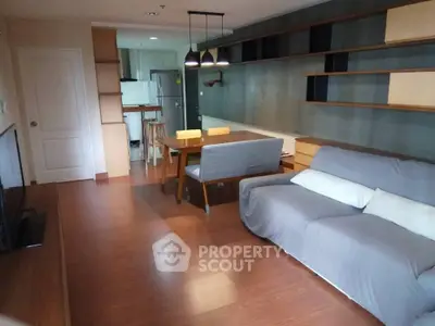 Stylish open-plan living room with modern kitchen and cozy dining area, perfect for urban living.