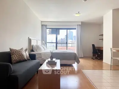 Spacious studio apartment with city view, modern furnishings, and natural light.