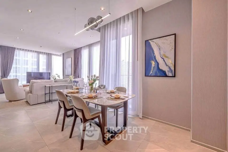 Luxurious open-plan living and dining area with elegant decor and large windows.