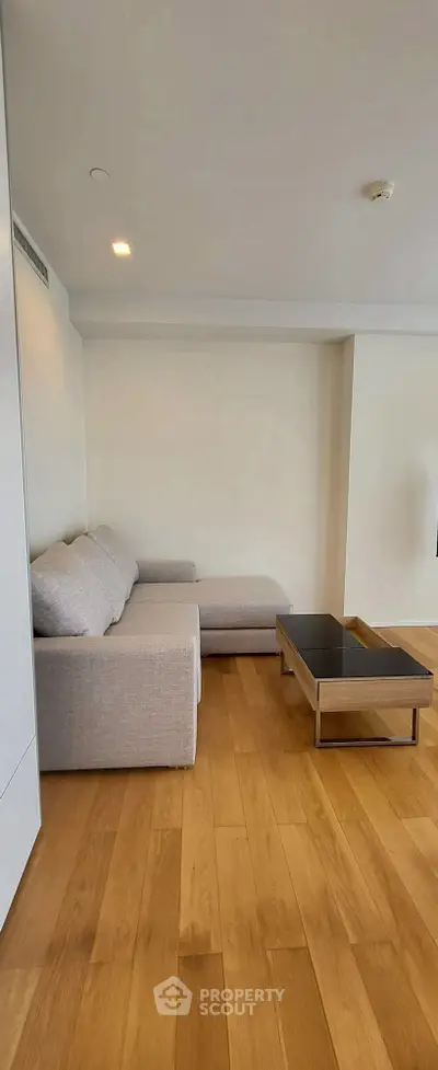 Modern living room with sleek wooden flooring and stylish furniture