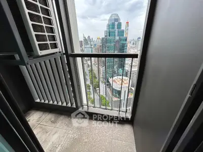 Stunning city view from a high-rise balcony with modern railing and tiled floor.