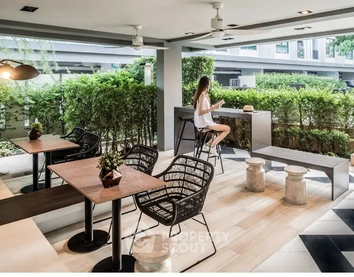 Chic outdoor seating area with modern furniture and lush greenery, perfect for relaxation.