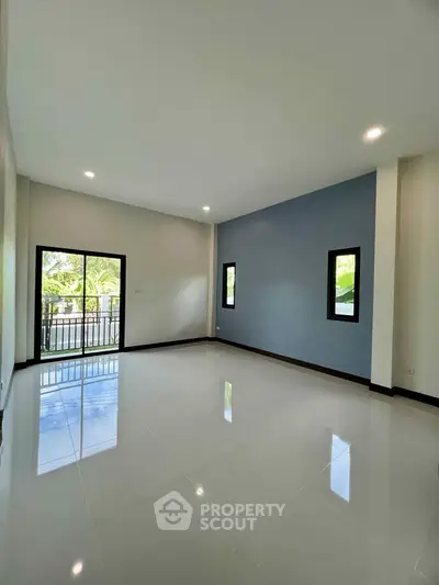 Spacious empty living room with large windows and glossy tiled floor