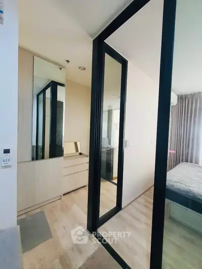 Modern bedroom with glass partition and wooden flooring in a stylish apartment.