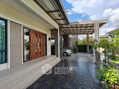 Modern home exterior with carport and lush garden, showcasing sleek design and spacious driveway.