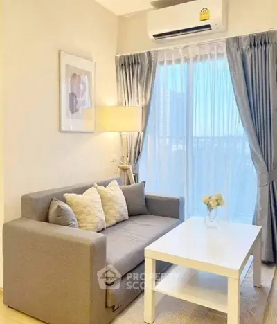 Cozy living room with modern sofa, stylish decor, and large window with city view.