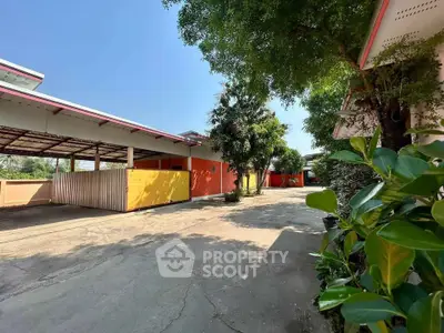 Spacious outdoor area with vibrant walls and lush greenery, perfect for residential or commercial use.