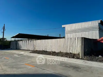 Industrial property with metal fencing and clear blue sky