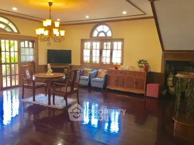 Elegant living room with polished wood floors and stylish chandelier