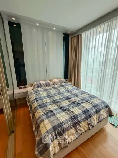 Cozy bedroom with large windows and modern decor in a stylish apartment.