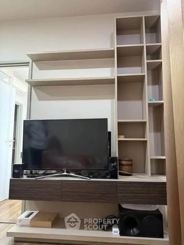 Modern living room with sleek TV unit and ample shelving for stylish storage solutions.