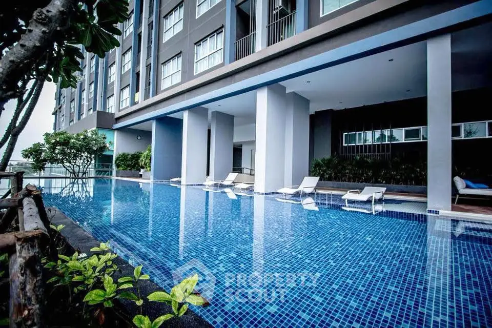 Luxurious apartment building with stunning poolside view and modern architecture.