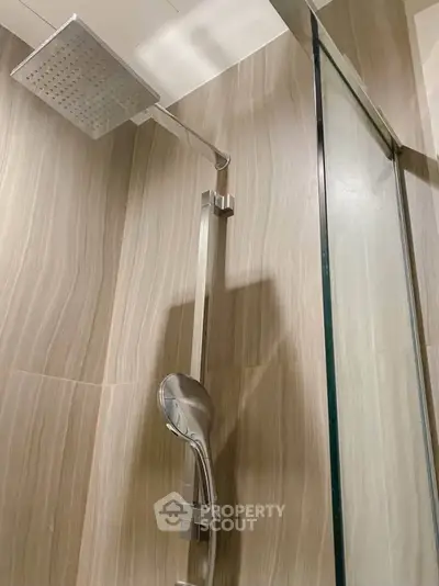 Modern bathroom shower with sleek design and glass partition in luxury real estate property.