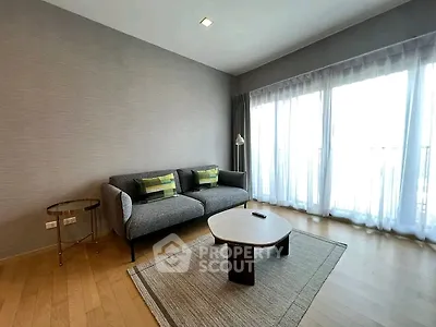 Modern living room with stylish sofa and large windows offering natural light.