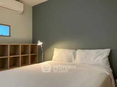 Cozy bedroom with modern design and soft lighting, featuring a comfortable bed and stylish shelving.