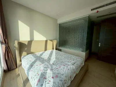 Spacious bedroom with large windows and modern decor in a luxury apartment.