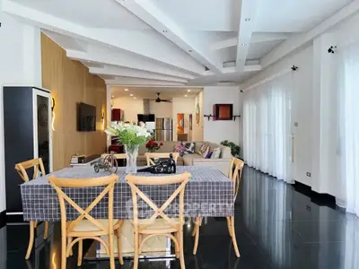 Spacious modern living room with dining area, stylish decor, and large windows for natural light.