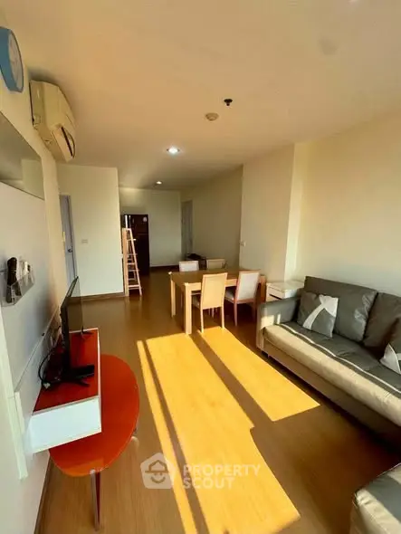 Spacious living room with modern furniture and abundant natural light in a stylish apartment.