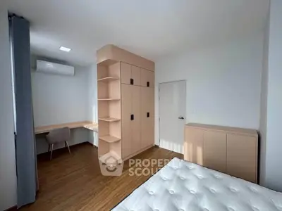Modern bedroom with built-in wardrobe and study desk, featuring sleek design and ample natural light.