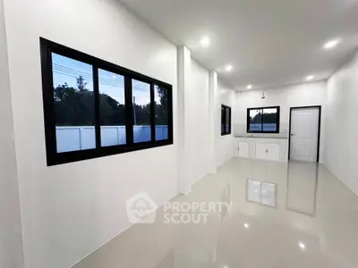 Spacious modern kitchen with sleek white cabinetry and large windows