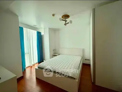 Spacious bedroom with modern decor and natural light in a stylish apartment.