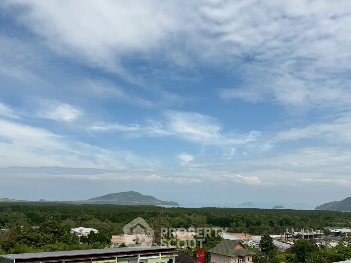 Stunning panoramic view of lush greenery and distant mountains under a clear blue sky.