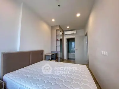 Modern bedroom with minimalist design and ensuite bathroom in a contemporary apartment.