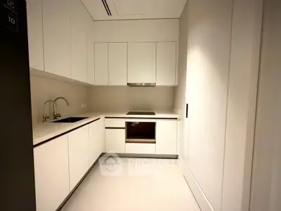 Modern kitchen with sleek white cabinetry and built-in appliances in a contemporary apartment.
