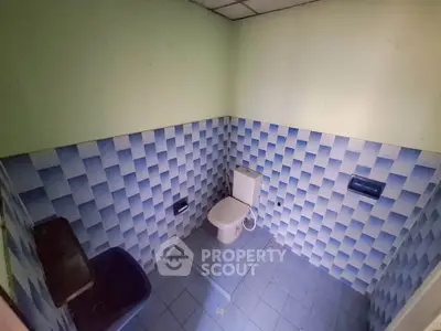 Unique blue-tiled bathroom with modern fixtures and creative wall design.