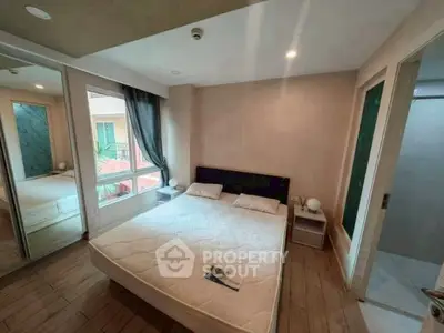 Cozy bedroom with mirrored closet and modern decor in urban apartment.