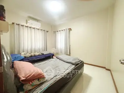 Cozy bedroom with air conditioning and natural light, perfect for relaxation.