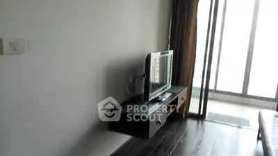Modern living room with sleek TV stand and large windows offering natural light.